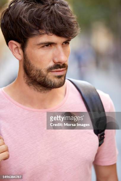 close-up of handsome male tourist looking away - strap stock pictures, royalty-free photos & images