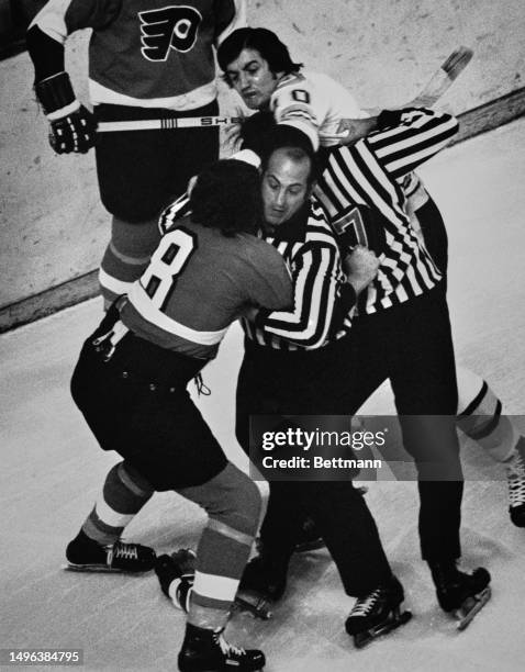 Officials attempt to separate the Boston Bruins' Carol Vadnais and the Philadelphia Flyers' Dave Schultz during a first period fight in the Stanley...