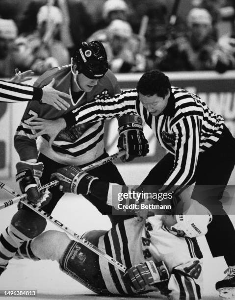Linesman Kevin Collins tries to break up a fight between the Chicago Blackhawks' Wayne Presley and the New York Rangers' Tony Granato in the first...