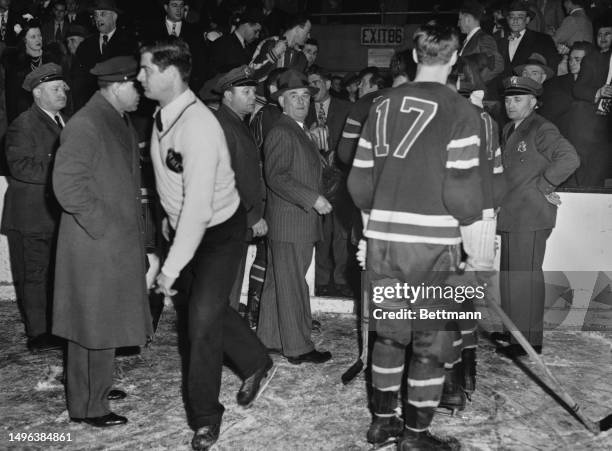 Officials and security guards restore order following a violent brawl involving players and fans during a game between New York Rangers and Montreal...