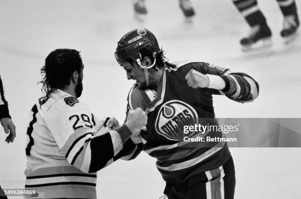 The Boston Bruins' Jay Miller and the Edmonton Oilers' Kevin McClelland exchange punches in the second period of the Stanley Cup Finals' third game...