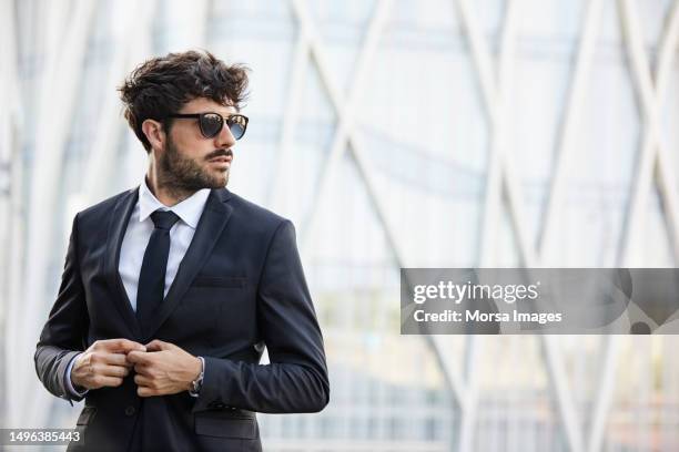 confident businessman in city looking away - südeuropa stock-fotos und bilder