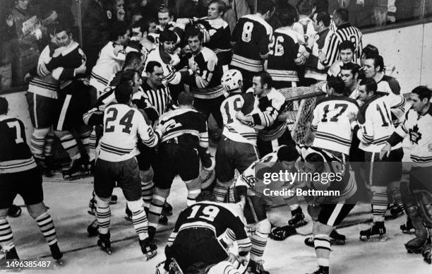 Players of the Boston Bruins and Toronto Maple Leafs join a fight which erupted during the second period of a game at the Boston Garden arena,...