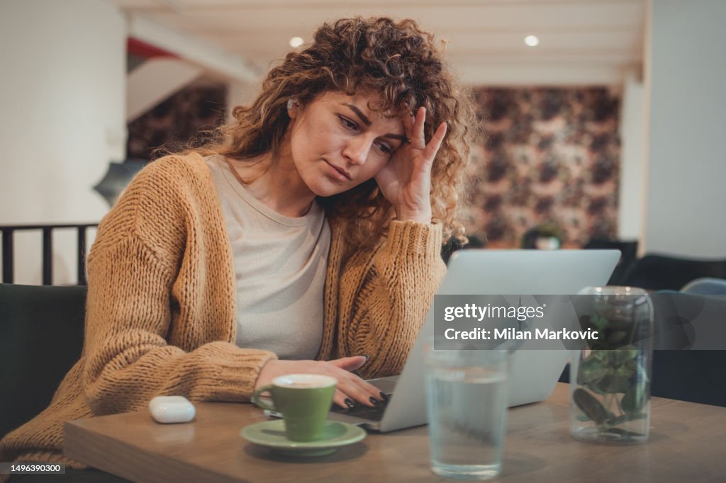 A young female freelancer who is visibly tired and nervous from too much work.