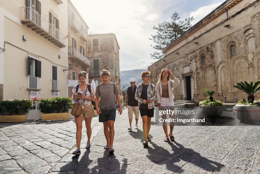 Multi generation family walking in a charming piazza of Tropea