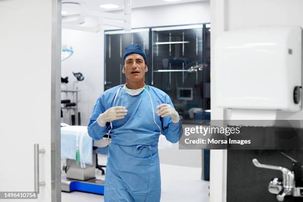 mature male surgeon walking in operating room - cure berlin 2016 stock pictures, royalty-free photos & images