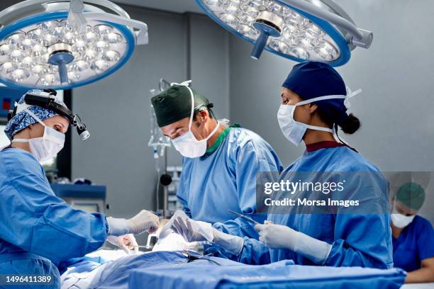 female surgeon operating patient at emergency room - operating stockfoto's en -beelden