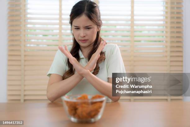 beautiful young asian woman refuses to eat junk food or fast food. - meat forbidden stock pictures, royalty-free photos & images