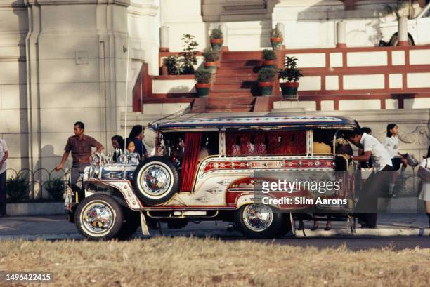 Crowded jeepney picks up passengers on a street in Manila, Philippines, 1974.
