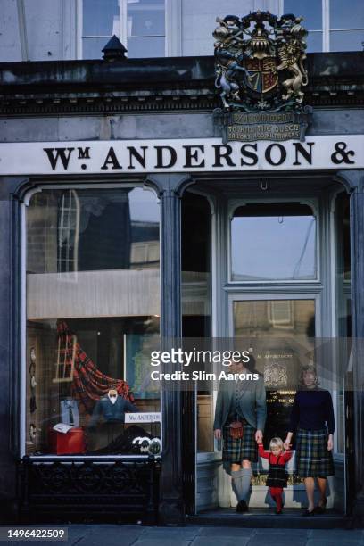 Family dressed in tartan in the doorway of William Anderson and Sons on George Street, Edinburgh, Scotland, 1964.