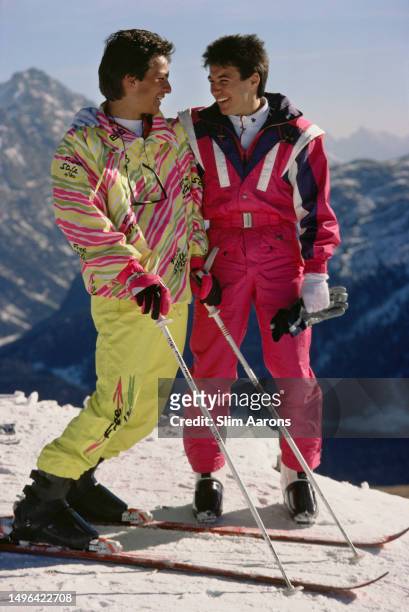 Two skiers wearing brightly coloured skiwear on the slopes of St. Moritz, Switzerland, 1989.