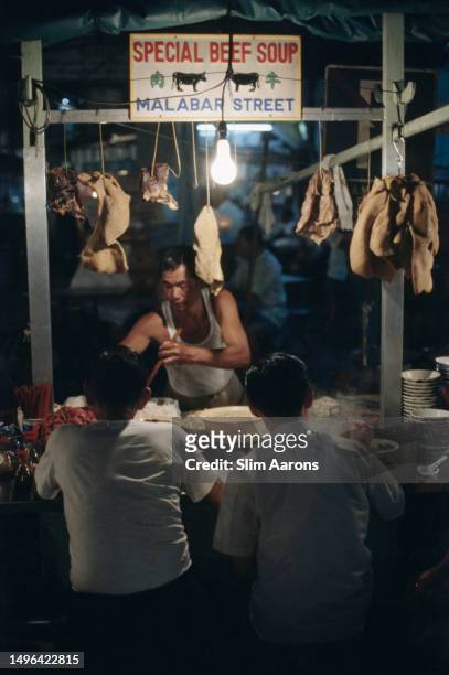 Soup vendor serves customers from a stall on Malabar Street, Singapore, 1971.