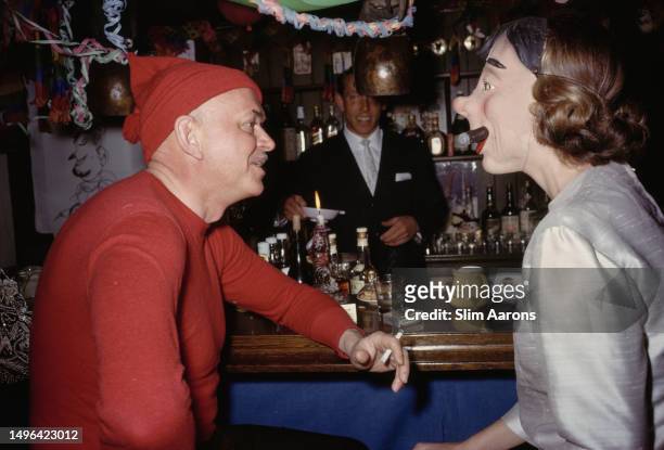 Howard Head, American aeronautical engineer and founder of the ski manufacturing firm 'Head', talks to a friend wearing a mask, Klosters,...