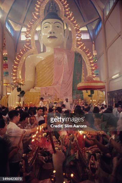 Statue of the Buddha overlooks a crowd inside the Sakya Muni Buddha Gaya Temple - also known as the 'Temple of a Thousand Lights' - in Singapore,...