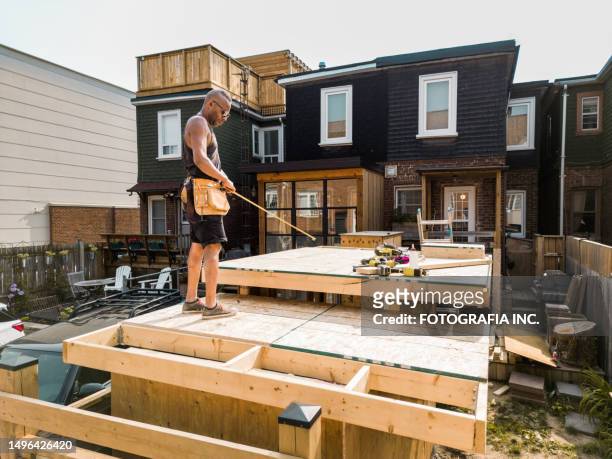male carpenter building shed in the backyard - backyard deck stock pictures, royalty-free photos & images