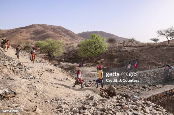 Woman from the city of Barentu carry bags of concrete mixture and rocks as members of the community complete a damn and reservoir project on the...