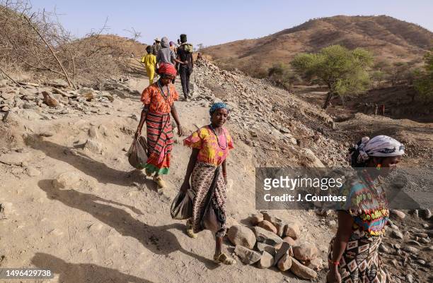 Woman from the city of Barentu carry bags of concrete mixture and rocks as members of the community complete a damn and reservoir project on the...