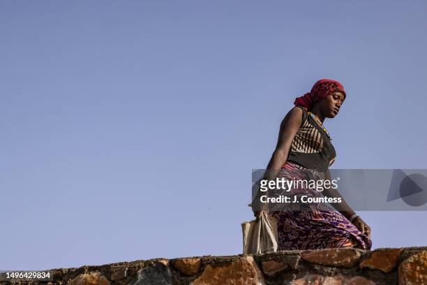 Woman from the city of Barentu carries a bag of concrete mixture as she and members of her community complete a damn and reservoir project on the...