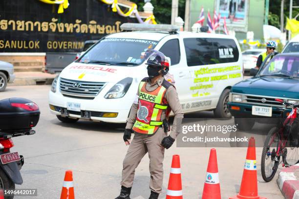 thai traffic cop  standing in street of phitsanulok. - verkeerspolitie stockfoto's en -beelden