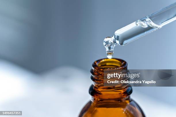 open amber bottle dropper pipette with liquid gel or serum. niacinamide or collagen - retinol stock pictures, royalty-free photos & images