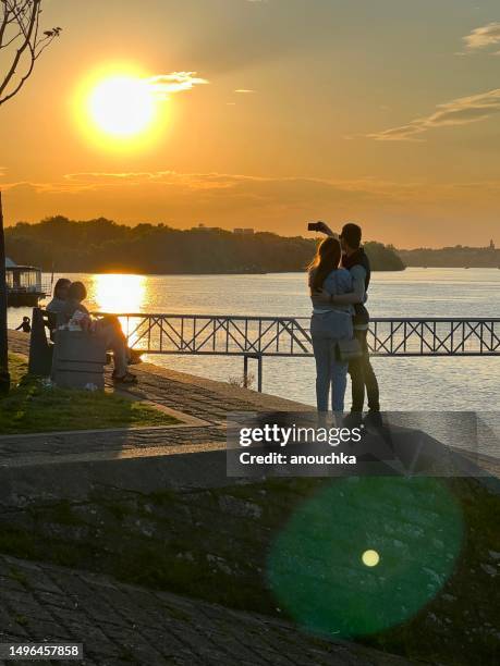 people enjoying sunset on danube river embankment, belgrade, serbia - belgrade skyline stockfoto's en -beelden