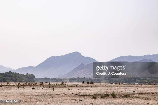 Group of travelers pass over the dried riverbed of the Barka river on May 22, 2023 in Akordat, Eritrea. According to the Ministry of Agriculture...