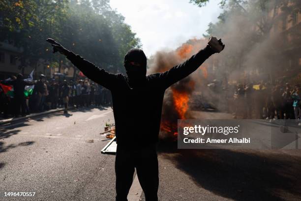 Demonstrator stands in a front fire that broke out during a protest against pension reform on June 06, 2023 in Paris, France. France's unions made a...