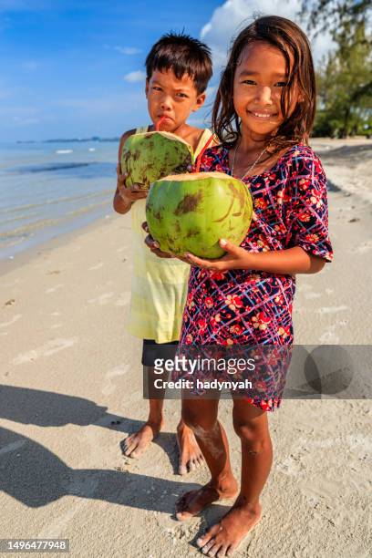 カンボジアの子どもたちがビーチでカンボジアのココナッツ ミルクを飲む - 2 coconut drinks ストックフォトと画像