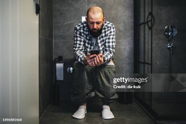 man using smart phone in toilet - men taking a dump stock pictures, royalty-free photos & images