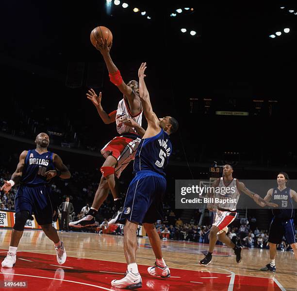 Guard Cuttino Mobley of the Houston Rockets shoots over forward Juwan Howard of the Dallas Mavericks during the NBA game at the Compaq Center in...