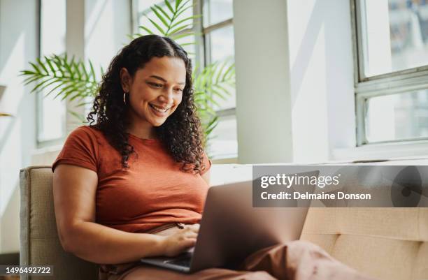 shot of a young black woman sitting with her laptop computer, smiling with copy space. stock photo - computador portátil imagens e fotografias de stock
