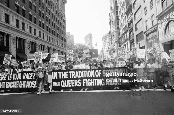 Demonstrators carry sign about Queers Fighting AIDS during a Gay Pride Parade on June 26, 1994 in New York City in New York.