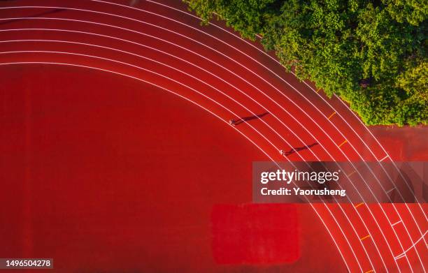 aerial view of runners running on red tartan track in the morning, like music note - orchestra pit stockfoto's en -beelden