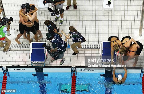 Shannon Vreeland, Missy Franklin, Allison Schmitt and Dana Vollmer of the United States celebrate next to team Australia after the UNited States won...