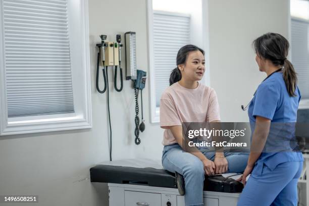 young woman at a medical appointment - clinic stock pictures, royalty-free photos & images