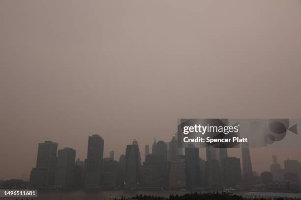 The Manhattan skyline stands shrouded in a reddish haze as a result of Canadian wildfires on June 06, 2023 in New York City. Over 100 wildfires are...