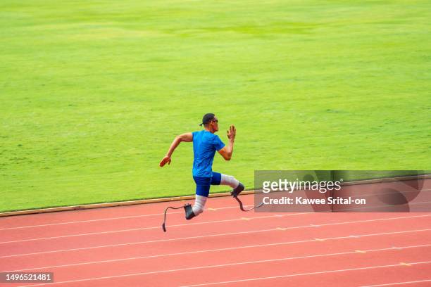 asian para-athletes disabled with prosthetic blades running at stadium. attractive amputee male runner exercise and practicing workout for paralympics competition regardless of physical limitations. - paralympics track stock pictures, royalty-free photos & images