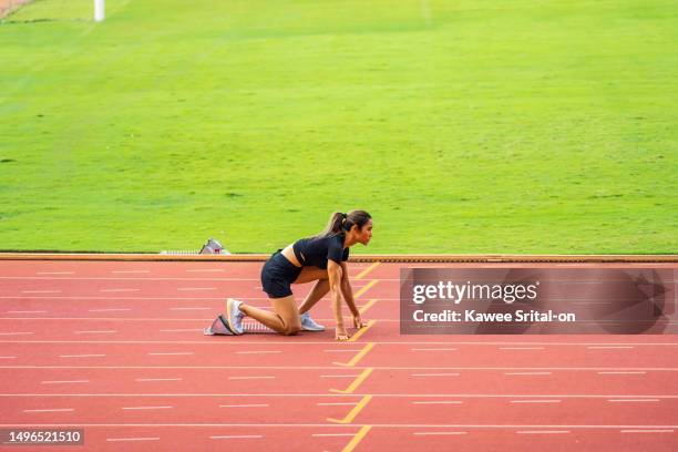 asian young sportswoman sprint on a running track outdoors on stadium. attractive strong athlete girl runner exercise and practicing workout speed running marathon on the race for olympics competition - olympiastadion rasen stock-fotos und bilder