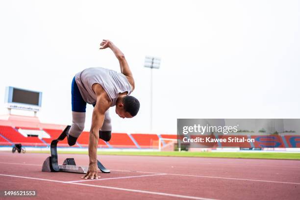 asian para-athletes disabled with prosthetic blades running at stadium. attractive amputee male runner exercise and practicing workout for paralympics competition regardless of physical limitations. - para athletics 個照片及圖片檔