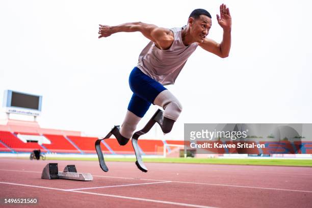 asian para-athletes disabled with prosthetic blades running at stadium. attractive amputee male runner exercise and practicing workout for paralympics competition regardless of physical limitations. - paralympics track stock pictures, royalty-free photos & images