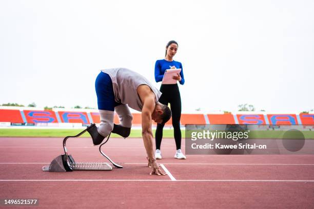 asian para-athlete with prosthetic blades and trainer workout instadium. attractive amputee male runner and sportswoman exercise and practice workout for paralympics running competition in sport court - running coach stock pictures, royalty-free photos & images