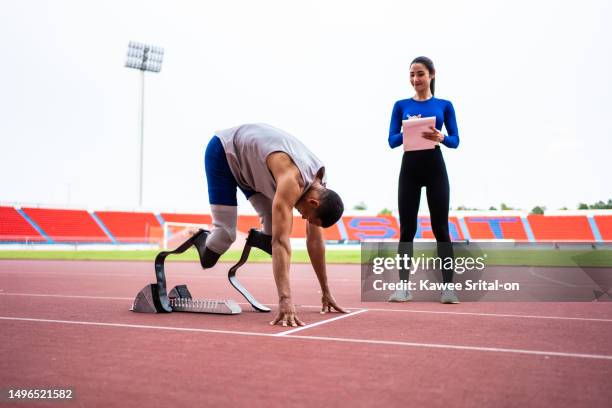 asian para-athlete with prosthetic blades and trainer workout instadium. attractive amputee male runner and sportswoman exercise and practice workout for paralympics running competition in sport court - running coach stock pictures, royalty-free photos & images