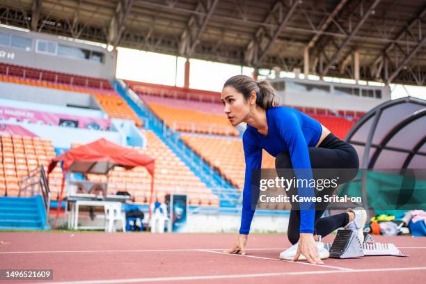 asian young sportswoman sprint on a running track outdoors on stadium. attractive strong athlete girl runner exercise and practicing workout speed running marathon on the race for olympics competition - women's track fotografías e imágenes de stock