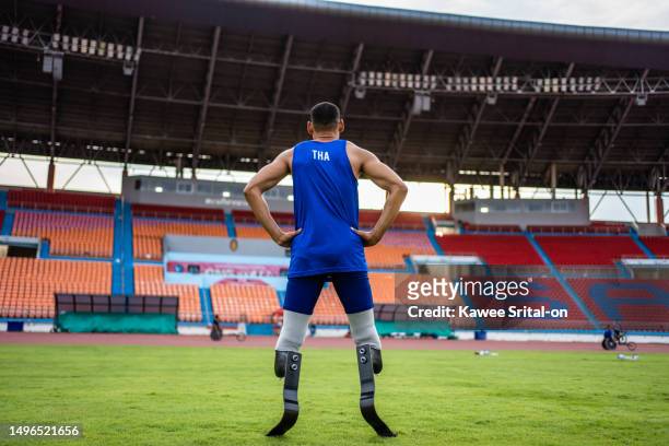 asian para-athletes disabled with prosthetic blades standing at stadium. attractive amputee male runner exercise and practicing workout for paralympics competition regardless of physical limitations. - paralympics track stock pictures, royalty-free photos & images