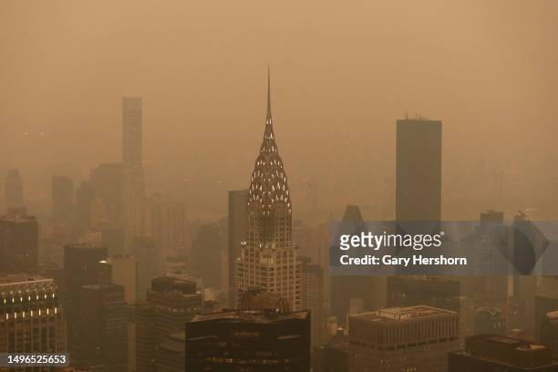 Heavy smoke shrouds the Chrysler Building in a view looking northeast from the Empire State Building as the sun sets on June 6 in New York City.
