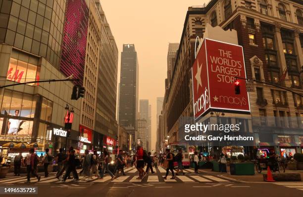 Heavy smoke fills the air as people cross 34th Street in Herald Square on June 6 in New York City.