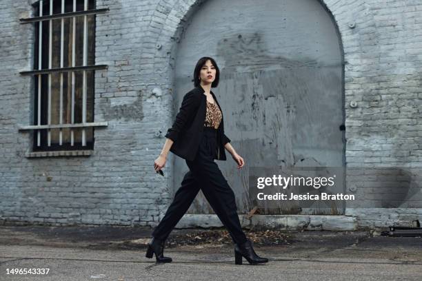 downtown woman in animal print pantsuit - black alley stock pictures, royalty-free photos & images