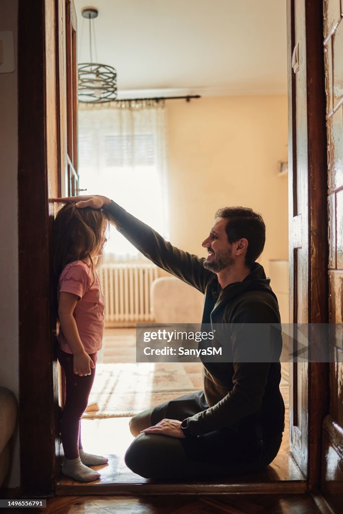 Father measuring daughter's height