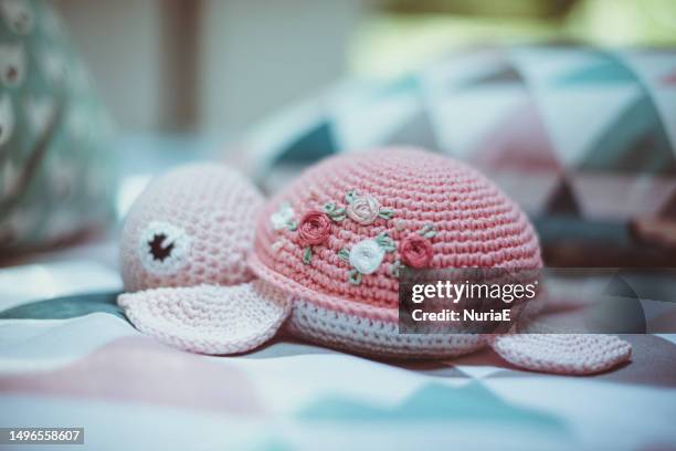 close-up of a homemade crochet turtle (amigurumi) on a bed in a camper van - toy tortoise stock pictures, royalty-free photos & images