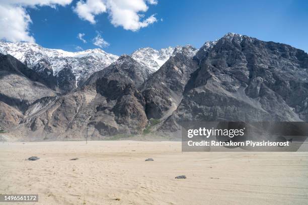 scenic aerial view drone view flying over sand dunes in sarfaranga cold desert, surrounding with snow cap mountain in skardu, northern pakistan - skardu stock pictures, royalty-free photos & images